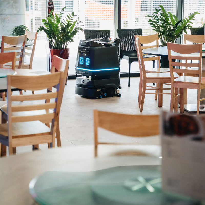 R3 schoonmaakrobot maakt schoon tussen de tafels en stoelen
